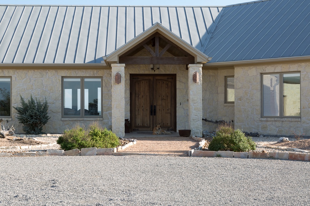 Timber framed entry at center of energy efficient custom home Texas Hill Country - Riverside Home Designs Custom Home Portfolio