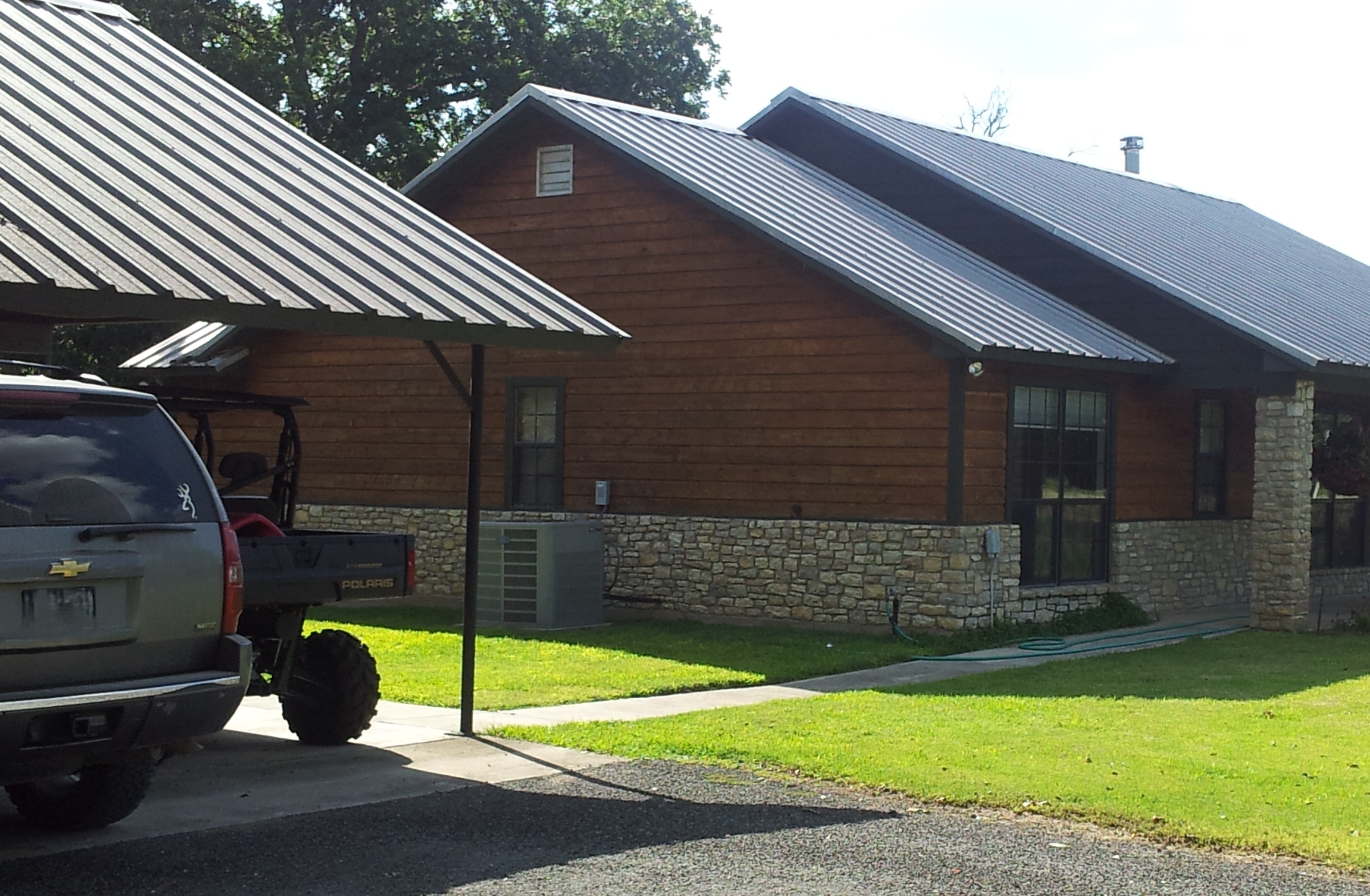 Warm Timber Craftsmanship Meets Nature - custom home with timber framing integrated with natural landscape - Riverside Home Designs Custom Home Portfolio